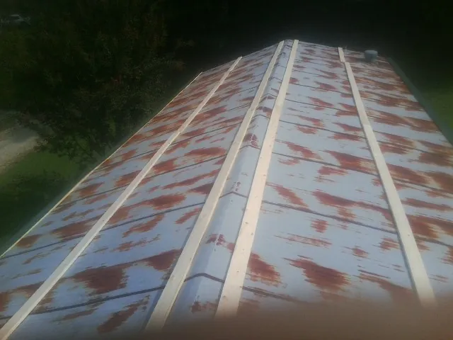 Rusted metal roof panels with new wood purlins before replacement — Storm Damage Roof Repair in Cordova by Roofing Brothers